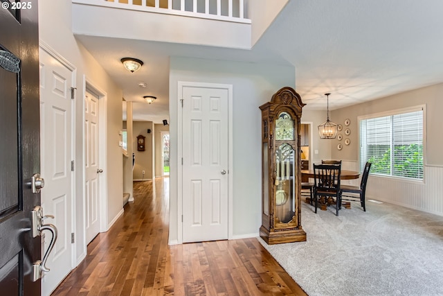 entrance foyer featuring a chandelier, wood finished floors, and wainscoting