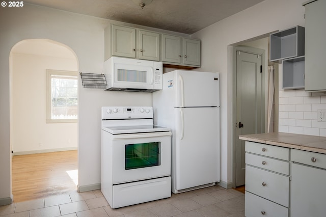 kitchen featuring tasteful backsplash, white appliances, tile counters, and light tile patterned flooring