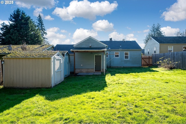 rear view of house featuring a yard and a shed