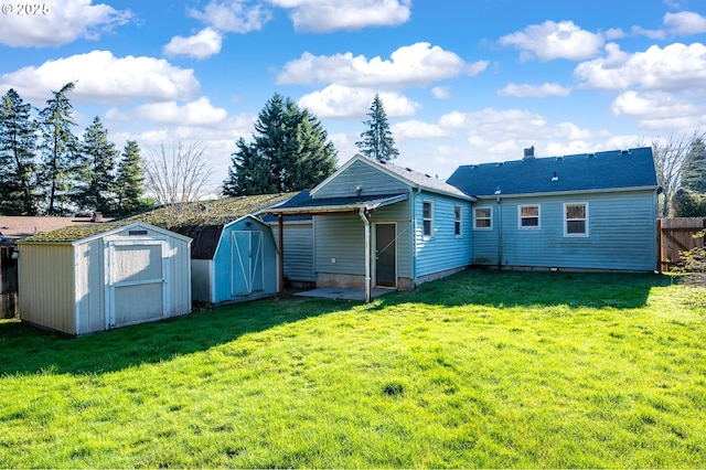 back of house with a yard and a storage unit