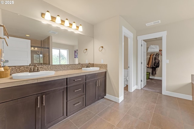 8070 SW 195th Ave, Beaverton, OR 97007 - full bathroom featuring a shower stall, double vanity, toilet, decorative backsplash, and a spacious closet