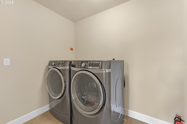 8070 SW 195th Ave, Beaverton, OR 97007 - washroom featuring washer and clothes dryer, baseboards, and wood finished floors