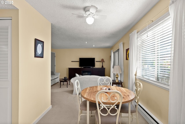 carpeted dining space featuring a textured ceiling, a baseboard radiator, and ceiling fan