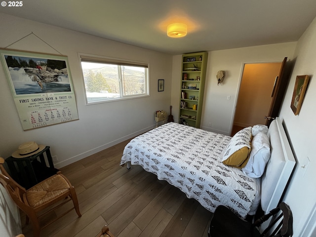 bedroom with wood finished floors and baseboards