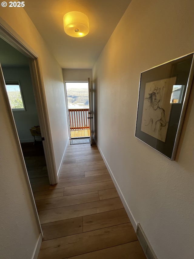 corridor featuring wood finished floors and baseboards