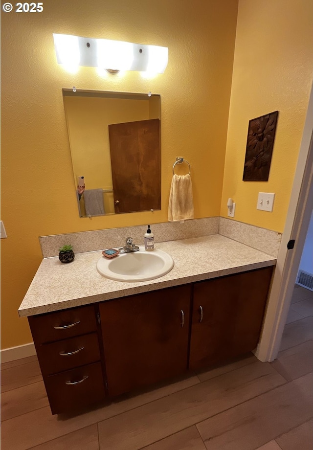 bathroom featuring visible vents, wood finished floors, and vanity
