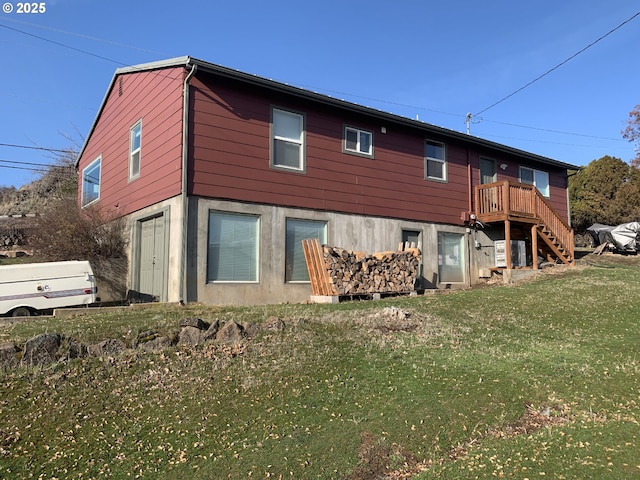 rear view of property featuring stairway and a lawn