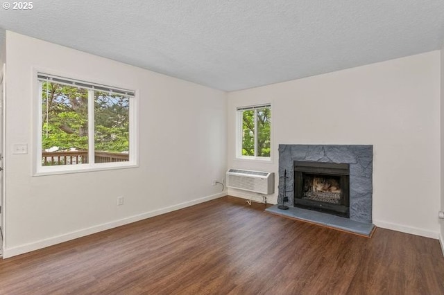 12062 SW Conestoga Dr, Beaverton, OR 97008 - unfurnished living room featuring a wall mounted AC, wood finished floors, baseboards, a high end fireplace, and a textured ceiling