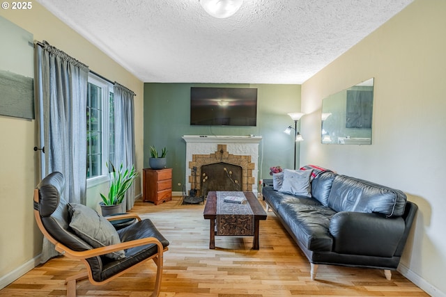 living room with baseboards, wood finished floors, and a fireplace