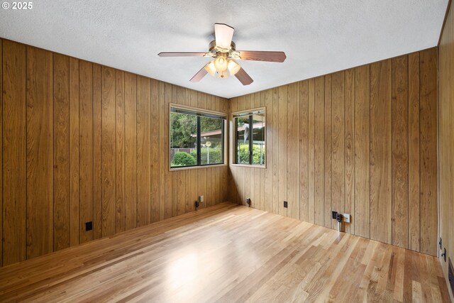 107 NW 10th Ave, Canby, OR 97013 - empty room with wood walls, a ceiling fan, wood finished floors, and a textured ceiling
