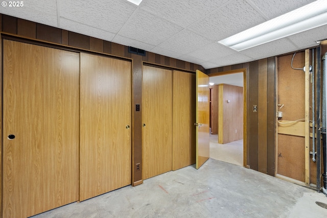 107 NW 10th Ave, Canby, OR 97013 - unfurnished bedroom with concrete floors, two closets, wood walls, and a paneled ceiling