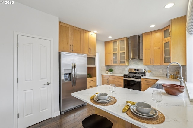 kitchen with wall chimney exhaust hood, a kitchen bar, stainless steel appliances, sink, and kitchen peninsula