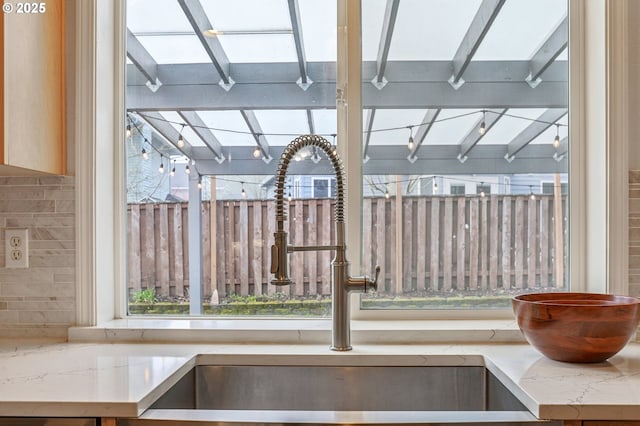 room details with tasteful backsplash, light stone counters, and sink