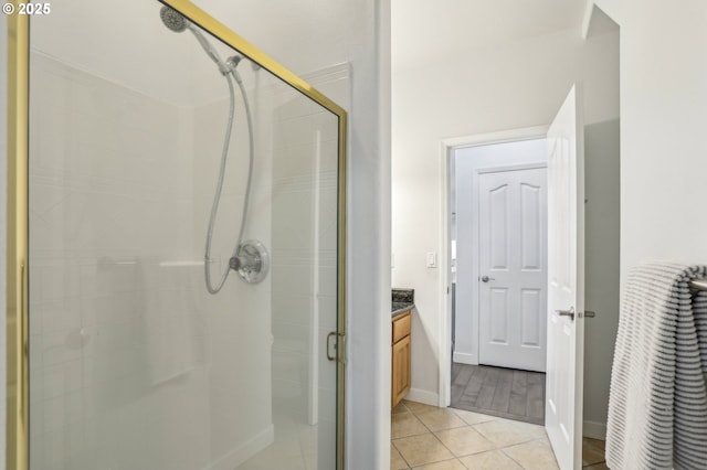 bathroom with walk in shower, vanity, and tile patterned flooring