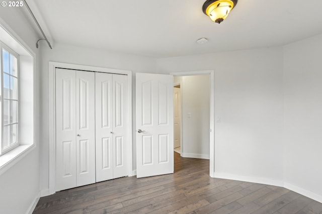 unfurnished bedroom with a closet and dark hardwood / wood-style floors