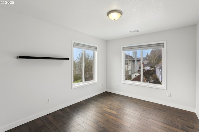 spare room with dark hardwood / wood-style flooring