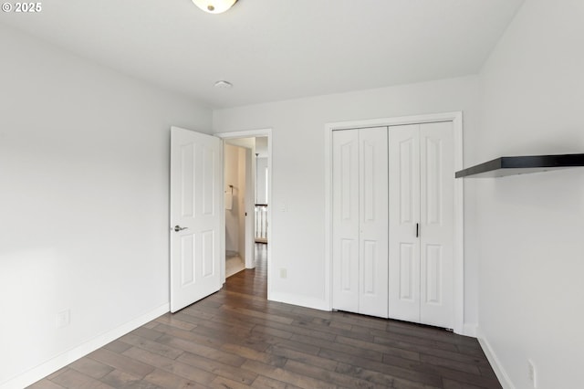 unfurnished bedroom with dark hardwood / wood-style floors and a closet