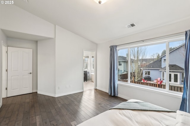 unfurnished bedroom with vaulted ceiling, ensuite bathroom, and dark hardwood / wood-style floors