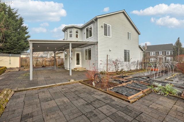 back of house featuring a storage unit and a patio