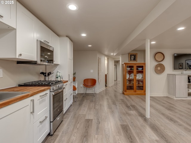 6310 NE 31st Ave Unit A, And B, Portland, OR 97211 - kitchen with stainless steel appliances, recessed lighting, white cabinets, butcher block countertops, and light wood-style floors