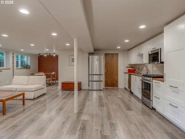 6310 NE 31st Ave Unit A, And B, Portland, OR 97211 - kitchen with appliances with stainless steel finishes, white cabinetry, light wood finished floors, recessed lighting, and baseboards