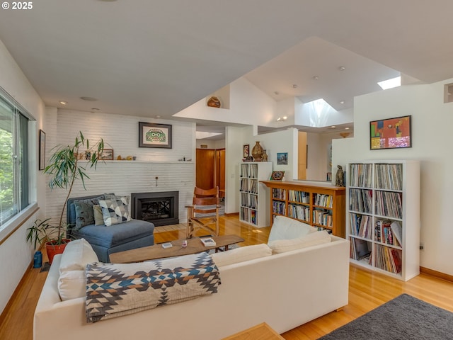 6310 NE 31st Ave Unit A, And B, Portland, OR 97211 - living room with a skylight, a fireplace, wood finished floors, and baseboards