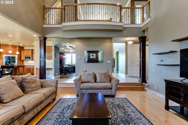 83500 Enterprise Rd, Creswell, OR 97426 - living area with ornate columns, light wood-style flooring, a high ceiling, arched walkways, and recessed lighting