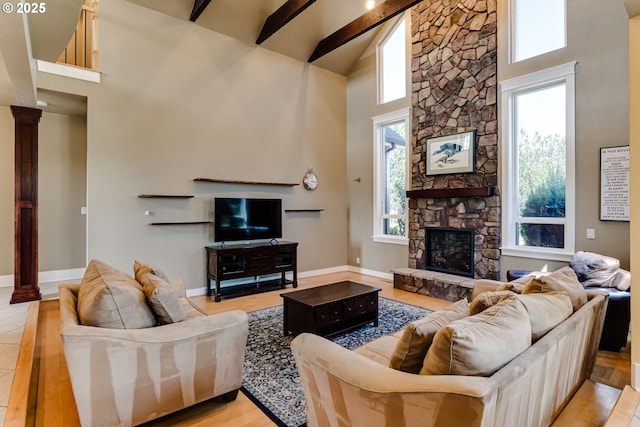 83500 Enterprise Rd, Creswell, OR 97426 - living room featuring high vaulted ceiling, beamed ceiling, healthy amount of natural light, a stone fireplace, and decorative columns