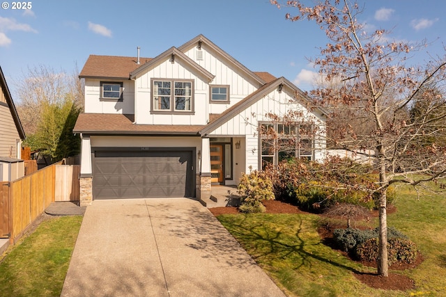 view of front facade with a garage, concrete driveway, stone siding, fence, and board and batten siding