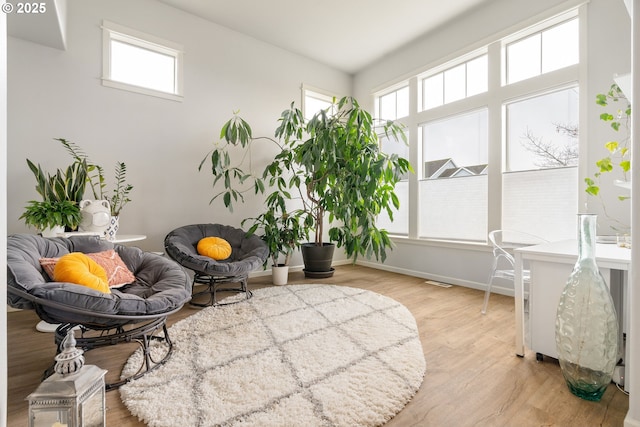 living area with baseboards and wood finished floors