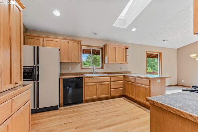 4311 NW 419th St, Woodland, WA 98674 - kitchen with white refrigerator with ice dispenser, dishwasher, a peninsula, a skylight, and light brown cabinetry