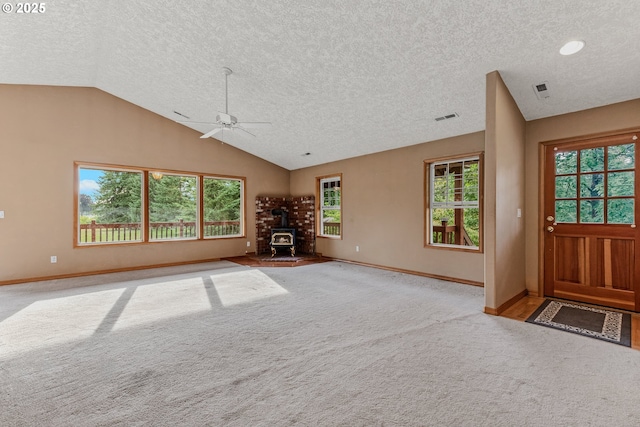 4311 NW 419th St, Woodland, WA 98674 - entrance foyer featuring lofted ceiling, a textured ceiling, ceiling fan, a wood stove, and carpet