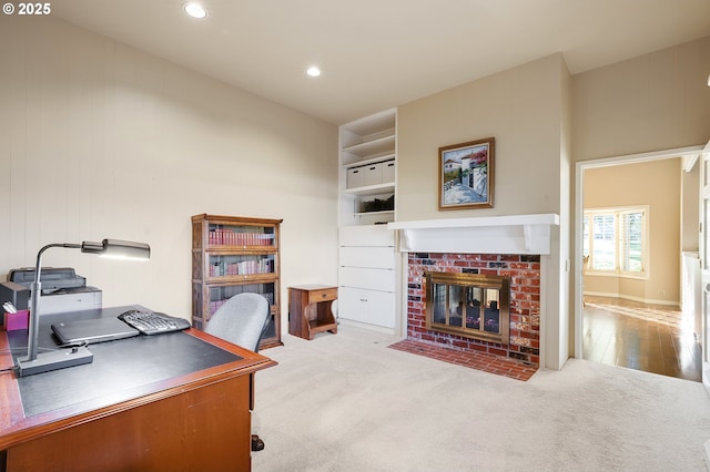 office area featuring light colored carpet and a fireplace