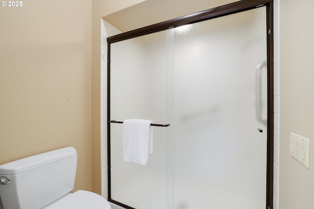 bathroom with toilet and an enclosed shower