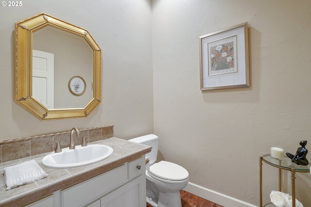 bathroom featuring toilet, a tile shower, and sink