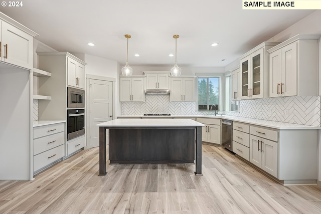 228 E 24th Ave, La Center, WA 98629 - kitchen with under cabinet range hood, stainless steel appliances, backsplash, light wood-type flooring, and light countertops