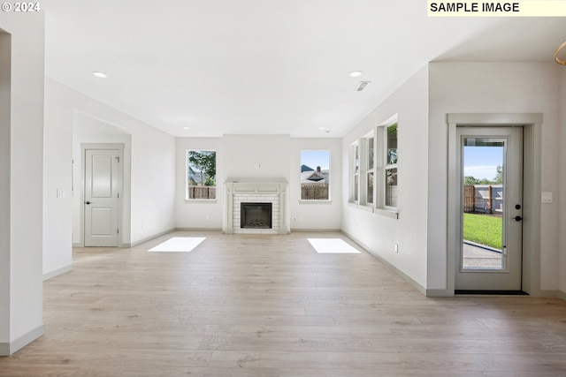 228 E 24th Ave, La Center, WA 98629 - unfurnished living room featuring light wood-style flooring, baseboards, a brick fireplace, and recessed lighting