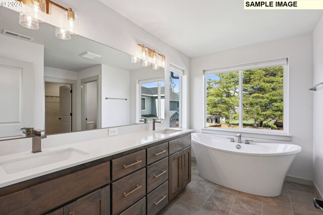 228 E 24th Ave, La Center, WA 98629 - full bath featuring double vanity, a freestanding tub, tile patterned floors, toilet, and baseboards