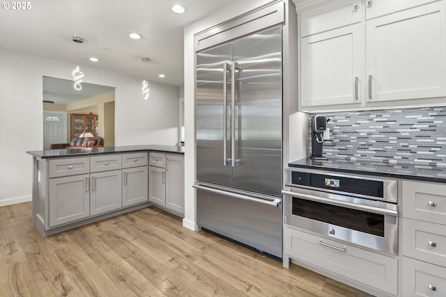 7375 SW 185th Ave, Beaverton, OR 97007 - kitchen with appliances with stainless steel finishes, dark countertops, a peninsula, recessed lighting, and light wood-style floors