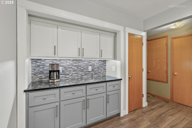 7375 SW 185th Ave, Beaverton, OR 97007 - kitchen featuring wood finished floors, decorative backsplash, dark stone countertops, and gray cabinetry
