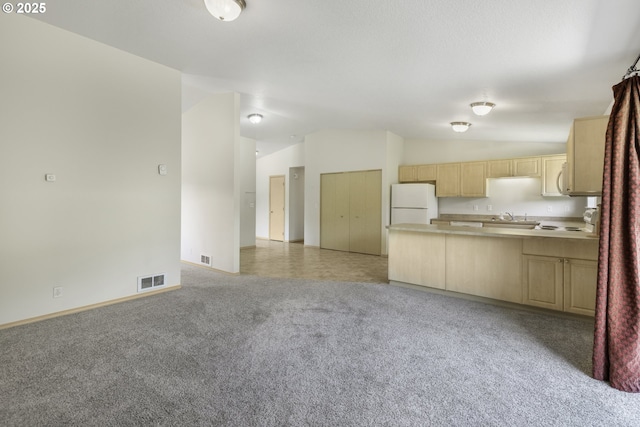 5580 Franklin Blvd, Eugene, OR 97403 - kitchen featuring freestanding refrigerator, lofted ceiling, light brown cabinets, a peninsula, and open floor plan