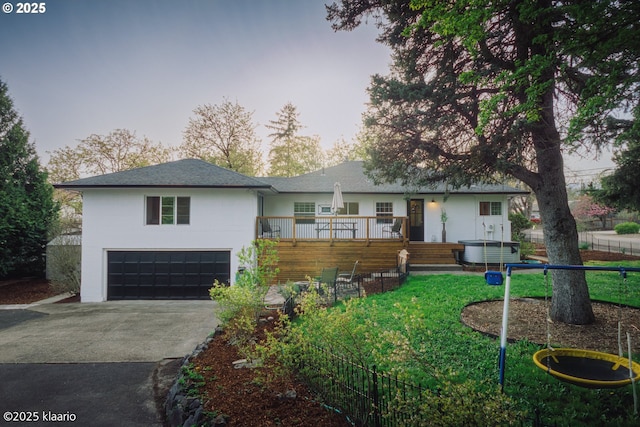 ranch-style home with a front lawn, aphalt driveway, a garage, a wooden deck, and stucco siding
