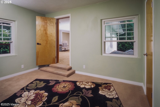 unfurnished bedroom featuring carpet flooring and baseboards
