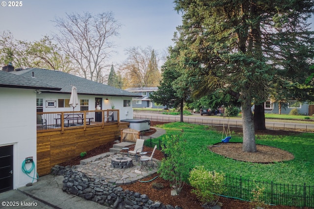 view of yard featuring a patio, a hot tub, an outdoor fire pit, and fence