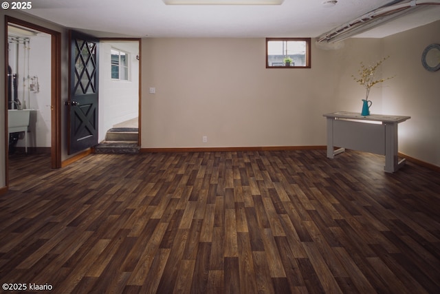 below grade area with baseboards and dark wood finished floors