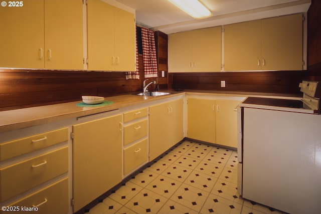 kitchen featuring light floors, a sink, electric range, and light countertops