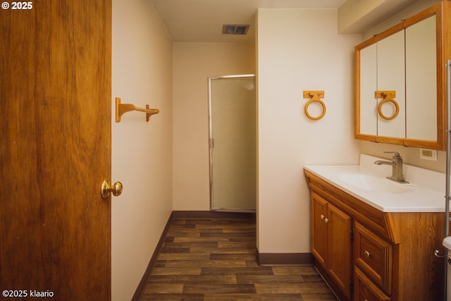 bathroom featuring visible vents, a stall shower, wood finished floors, vanity, and baseboards