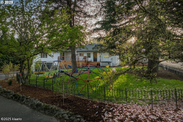 view of property hidden behind natural elements featuring fence private yard and a front yard