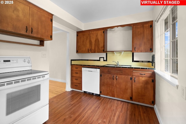 kitchen with sink, decorative backsplash, white appliances, and dark hardwood / wood-style floors