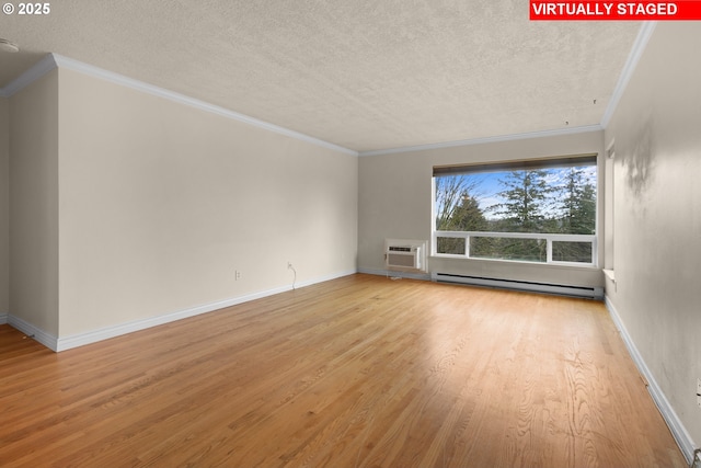 spare room with baseboard heating, a wall mounted AC, ornamental molding, and light hardwood / wood-style floors